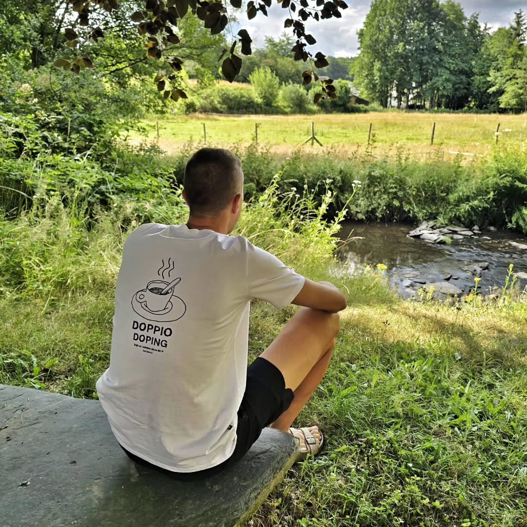 Gravelrijder in The Vandal-tee bij een beek
