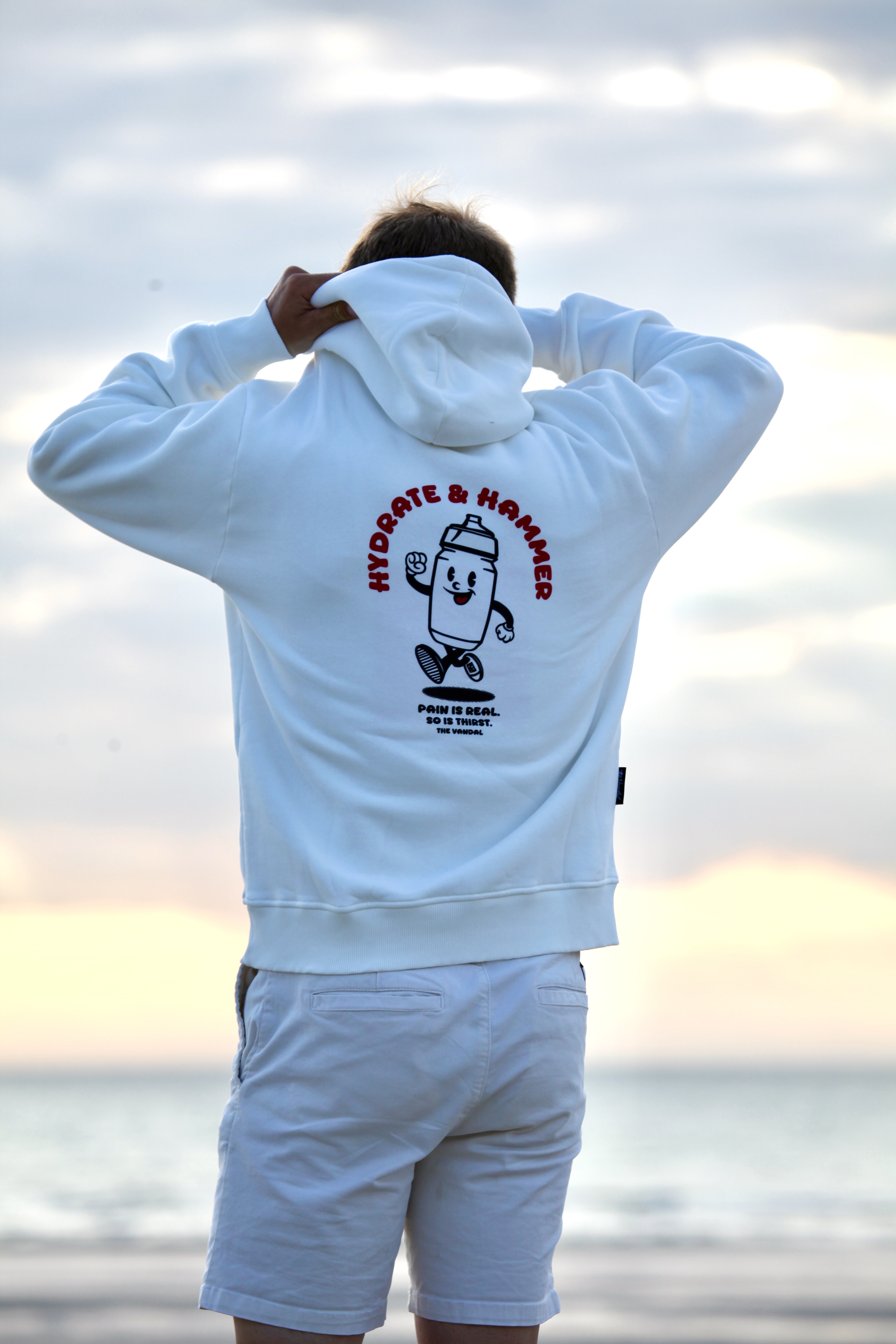 Sportfluencer in The Vandal-hoodie in de duinen bij zonsondergang